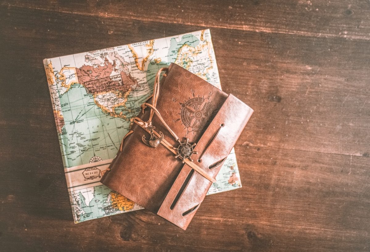 gift on a wood table wrapped in map wrapping paper with an outdoorsy journal on top