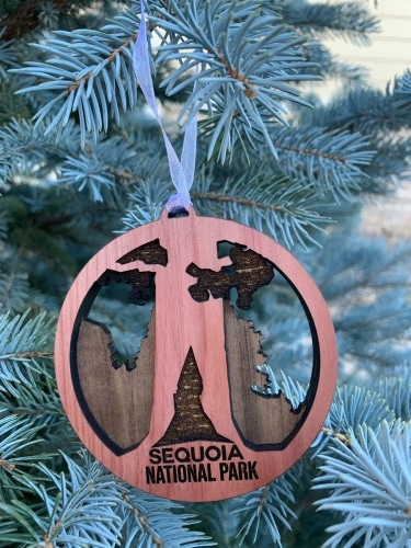 A wooden national park ornament of a tree in a circle with the words, Sequoia National Park.