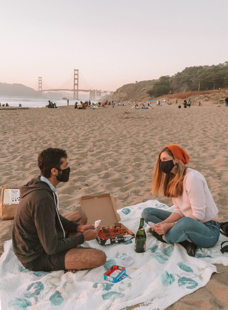 Couple playing cards at Baker Beach