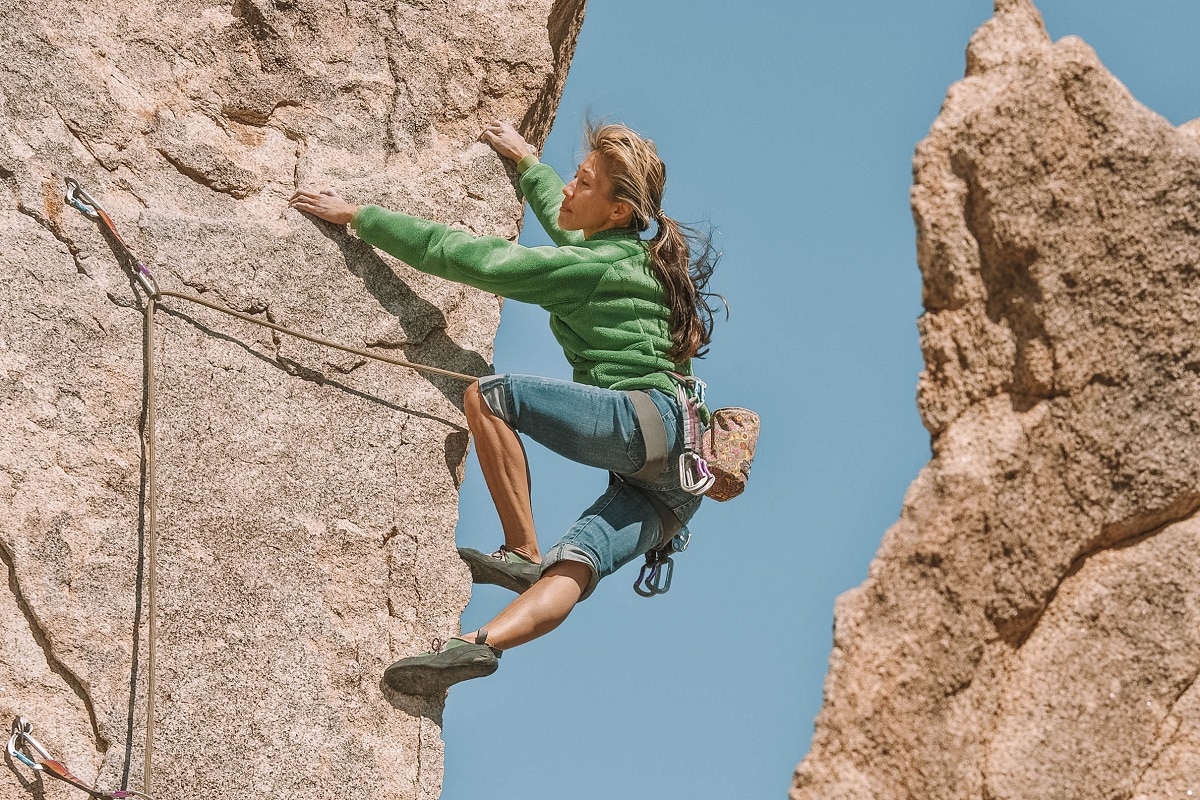 Female rock climber up steep cliff Joshua Tree National Park