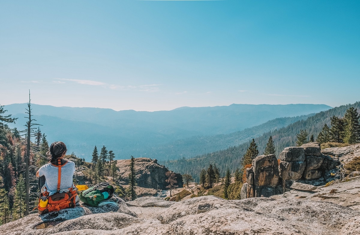 female hiker with a hiking fanny pack sitting on rocks