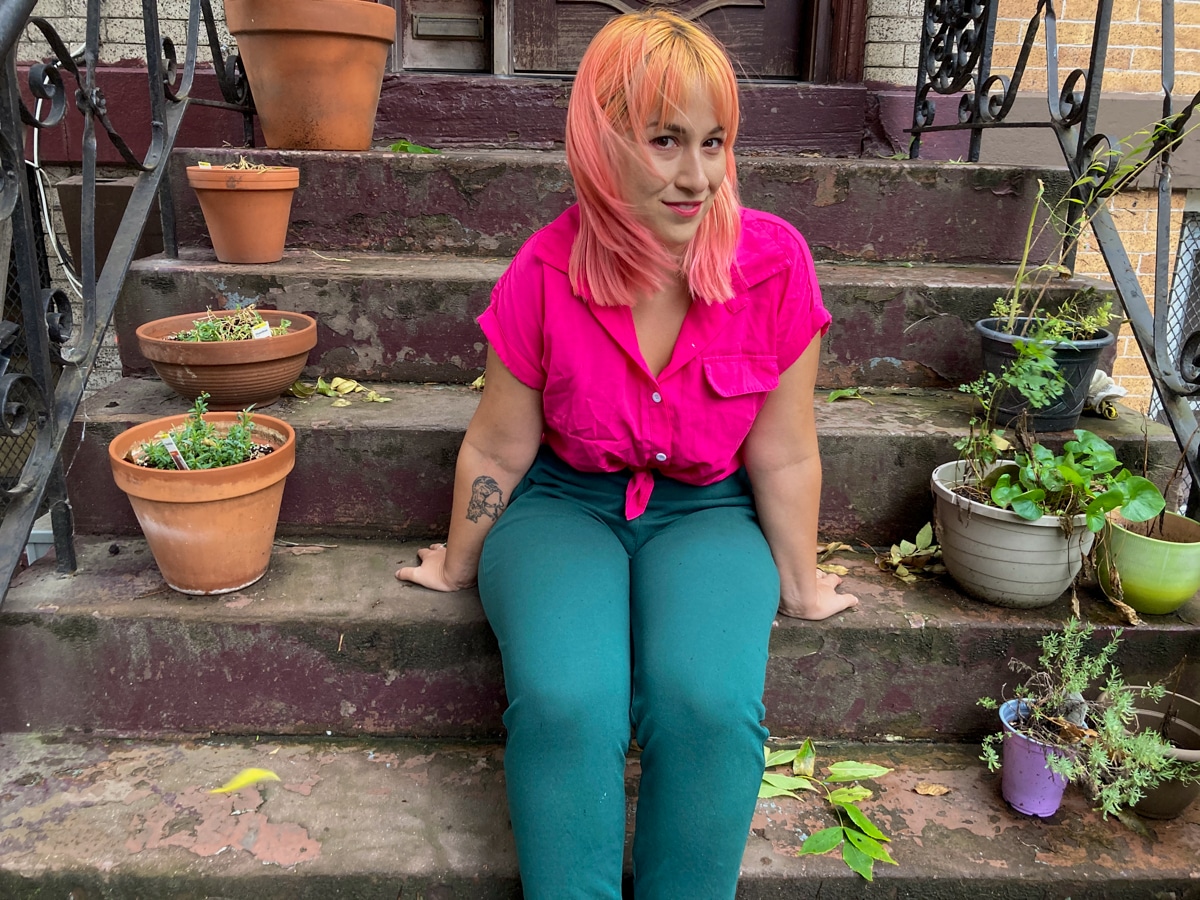 woman in a hot pink Emery Rose top and green pants