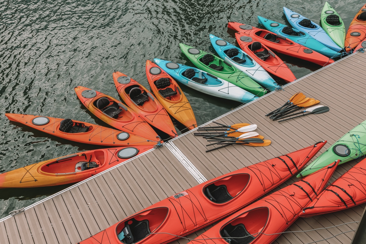 Picture of colorful kayaks parked at a dock, best kayak brands featured image.