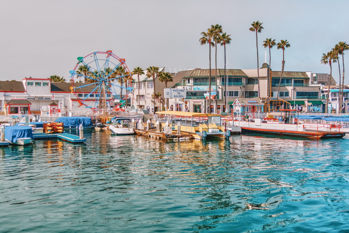 A picture of the famous pier at Balboa featuring boats, restaurants, shops and a Ferris wheel, best restaurants in Newport Beach featured image.