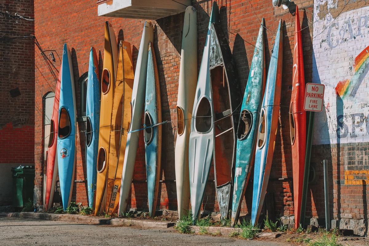 Colorful old kayaks leaned against the wall in the street