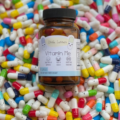 A jar of Vitamin Me message capsules.