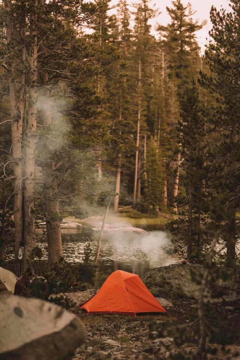 Picture of a tent and campfire near a lake