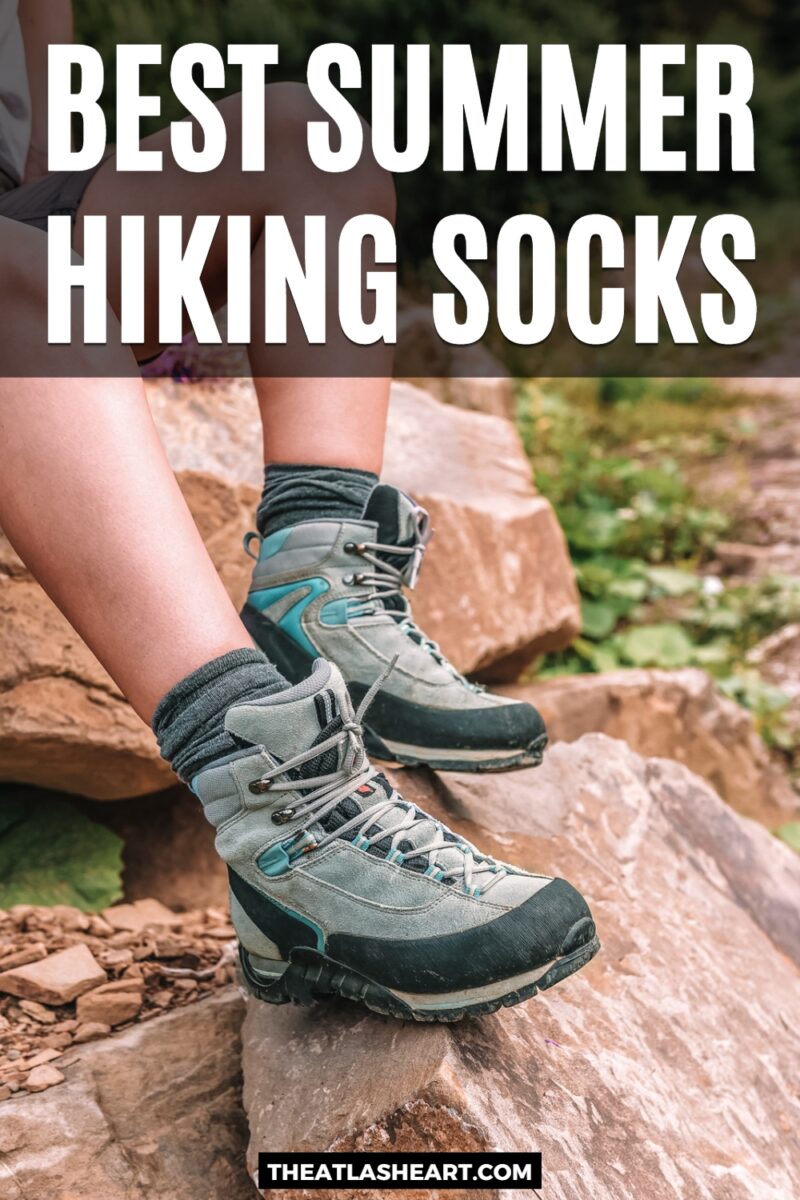 A pair of legs balanced on a boulder, wearing hiking boots and summer hiking socks in grey, with the text overlay, "Best Summer Hiking Socks."